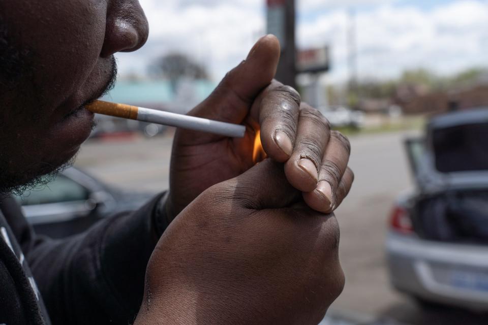 A man prepares to light a Newport 100 menthol cigarette outside of Big V Party Store on Greenfield Road in Detroit on Friday, April 30, 2021 while talking about the nationwide ban of menthol cigarettes aimed at protecting African Americans.