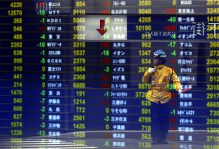 A traffic controller at a constructing site is reflected on a stock quotation board at a brokerage in Tokyo October 1, 2013. REUTERS/Issei Kato