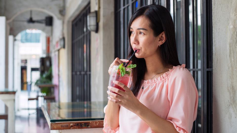 Woman drinking alcohol-free cocktail at bar