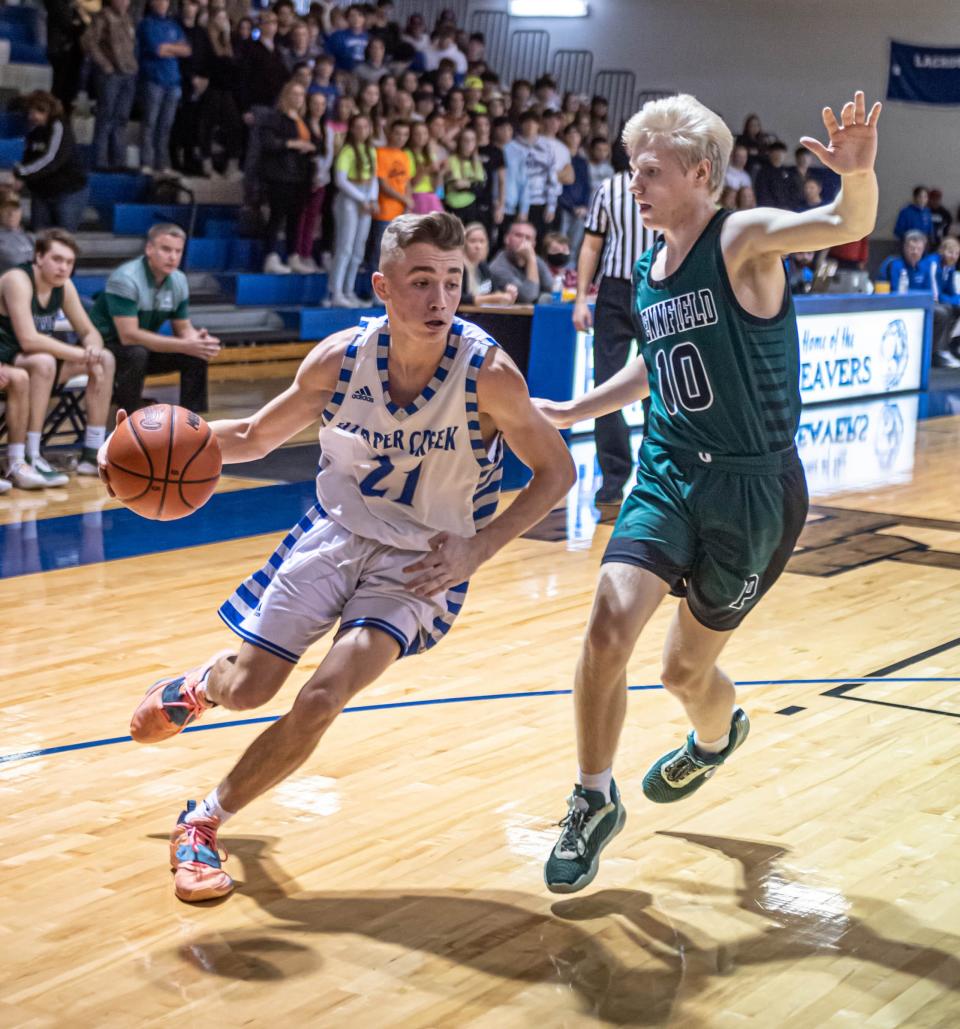 Harper Creek's Ty Peet drives to the basket as Pennfield's Aiden Burns defends during first half action at Harper Creek High School on January 14, 2022.