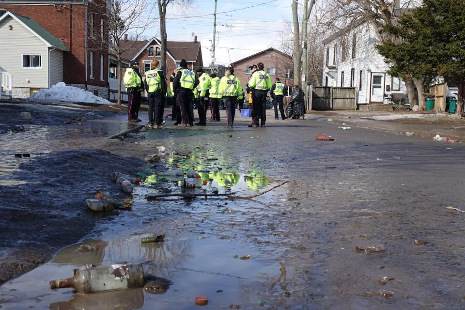 An empty bottle and other pieces of litter are strewn on a street in Kingston, Ont., after authorities cleared out a large party on March 18, 2023, the day after St. Patrick's Day.