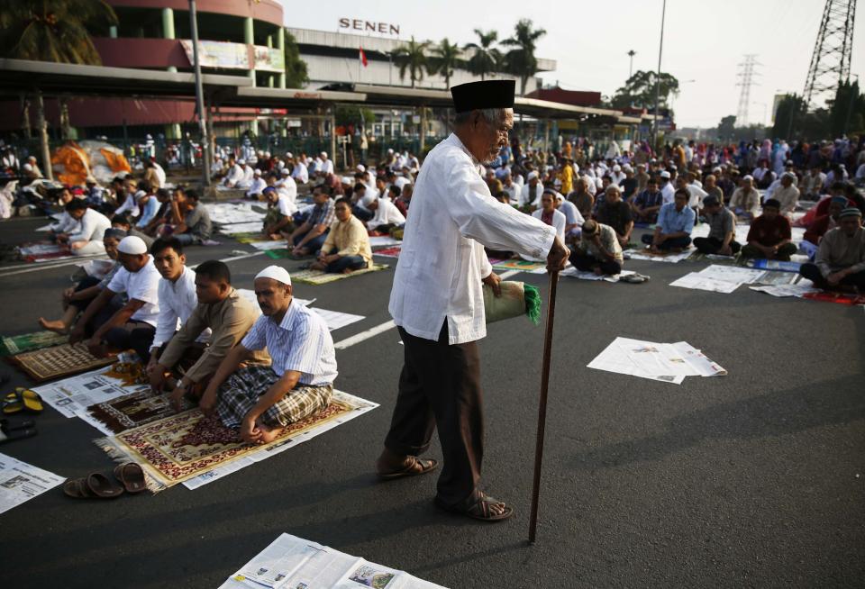 An Indonesian Muslim walks as he attends an Eid al-Adha mass prayer at Senen market in Jakarta