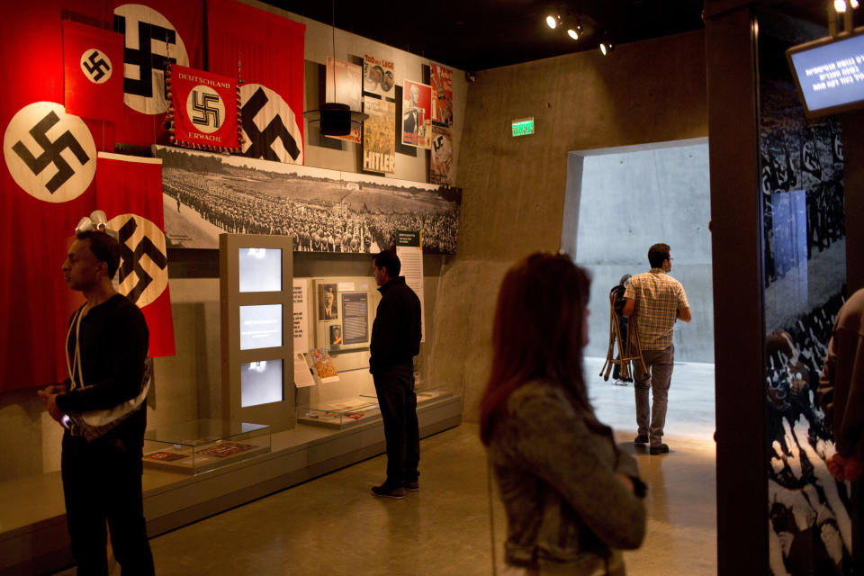 FILE - People look at an exhibit as they tour the Yad Vashem Holocaust Memorial Jerusalem, Sunday, April 23, 2017. U.S. President Joe Biden's dash through the Israel and the occupied West Bank this week is expected to cut across some of the region's most iconic places. Both luxurious and grueling, Biden's visit starts with a VIP arrival at Israel's main commercial airport and pings through Jerusalem and the occupied West Bank. In between his meetings with Israeli and Palestinian leaders, he will visit a host of well-known sites while staying at a historic Jerusalem hotel. (AP Photo/Oded Balilty, File)