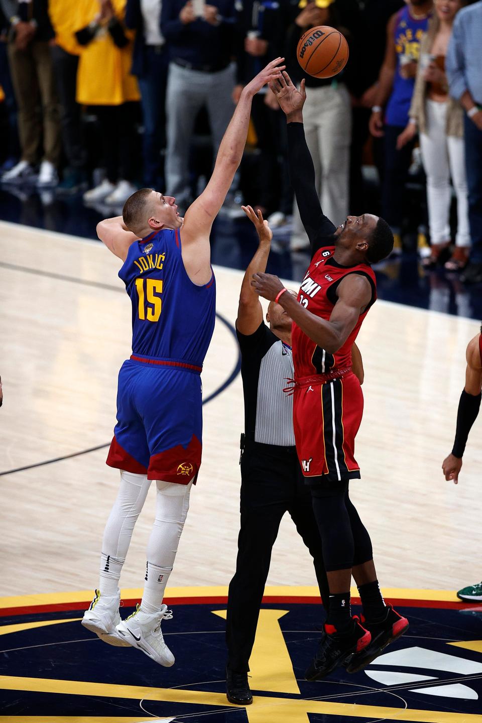 Nuggets center Nikola Jokic (15) and Heat center Bam Adebayo battle for the opening tip in Game 1 of the NBA Finals.