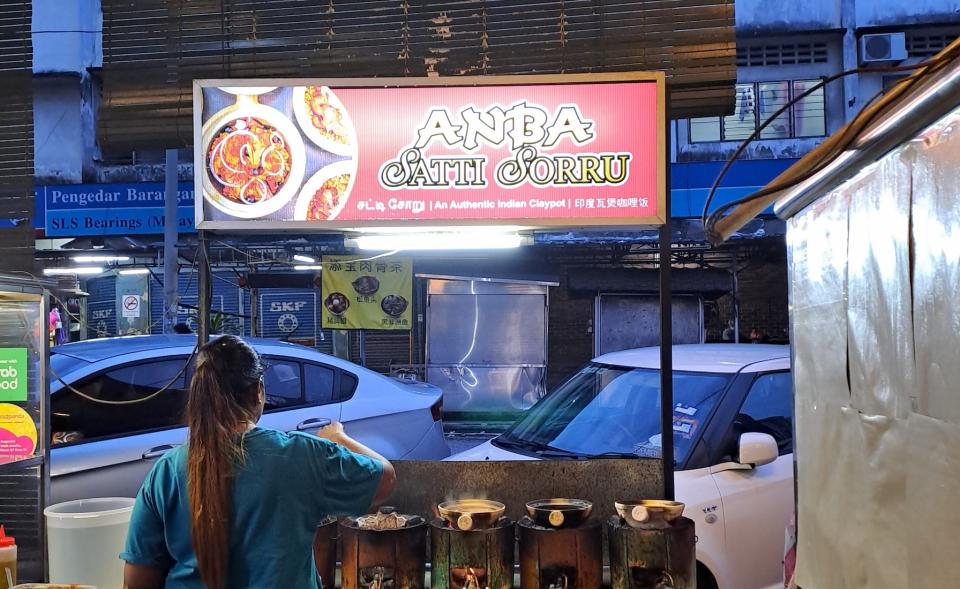 A claypot rice stall in Kuala Lumpur named Anba, with the chef cooking their famous claypot rice.