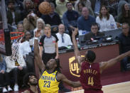 Indiana Pacers' Aaron Nesmith (23) and Cleveland Cavaliers' Evan Mobley (4) stretch for a rebound as Cavaliers' Jarrett Allen, left, watches during the first half of an NBA basketball game in Cleveland, Friday, April 12, 2024. (AP Photo/Phil Long)