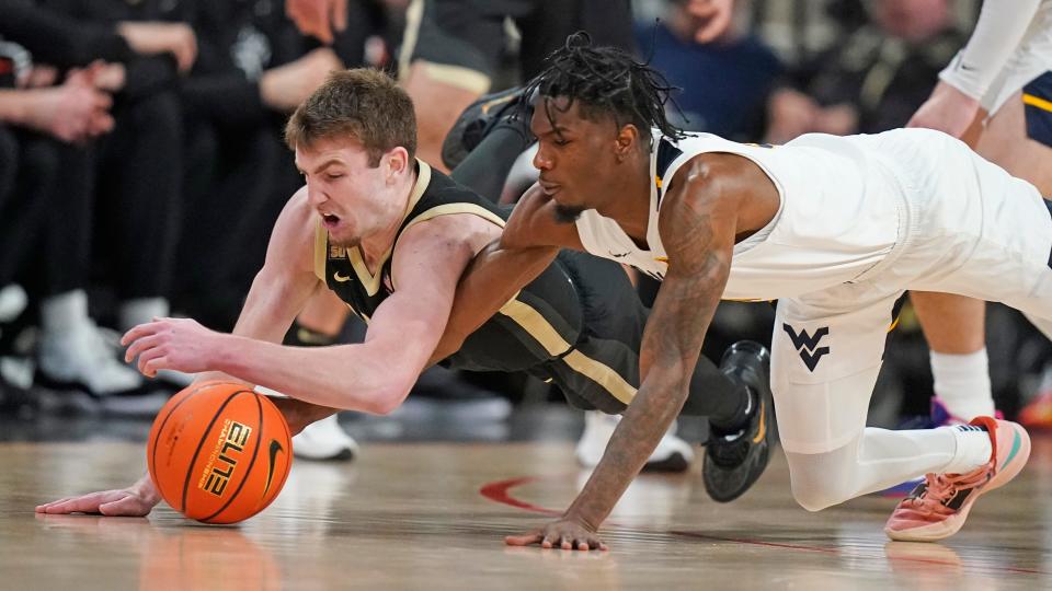 Purdue guard Braden Smith, left, and West Virginia guard Kedrian Johnson scramble for the ball during the second half of an NCAA college basketball game in the Phil Knight Legacy tournament Thursday, Nov. 24, 2022, in Portland, Ore. (AP Photo/Rick Bowmer)
