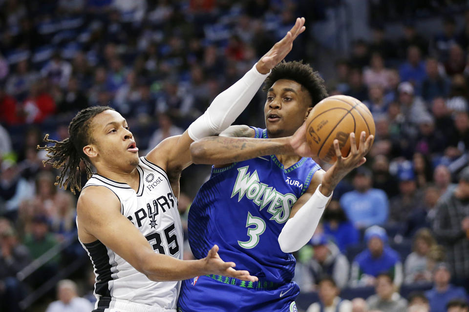 Minnesota Timberwolves forward Jaden McDaniels (3) passes with pressure from San Antonio Spurs guard Romeo Langford (35) in the first quarter during an NBA basketball game Thursday, April 7, 2022, in Minneapolis.(AP Photo/Andy Clayton-King)