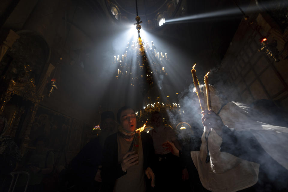 Christian pilgrims hold candles as they gather during the ceremony of the Holy Fire at the Church of the Holy Sepulchre, where many Christians believe Jesus was crucified, buried and rose from the dead, in the Old City of Jerusalem, Saturday, May 4, 2024. (AP Photo/Ohad Zwigenberg)