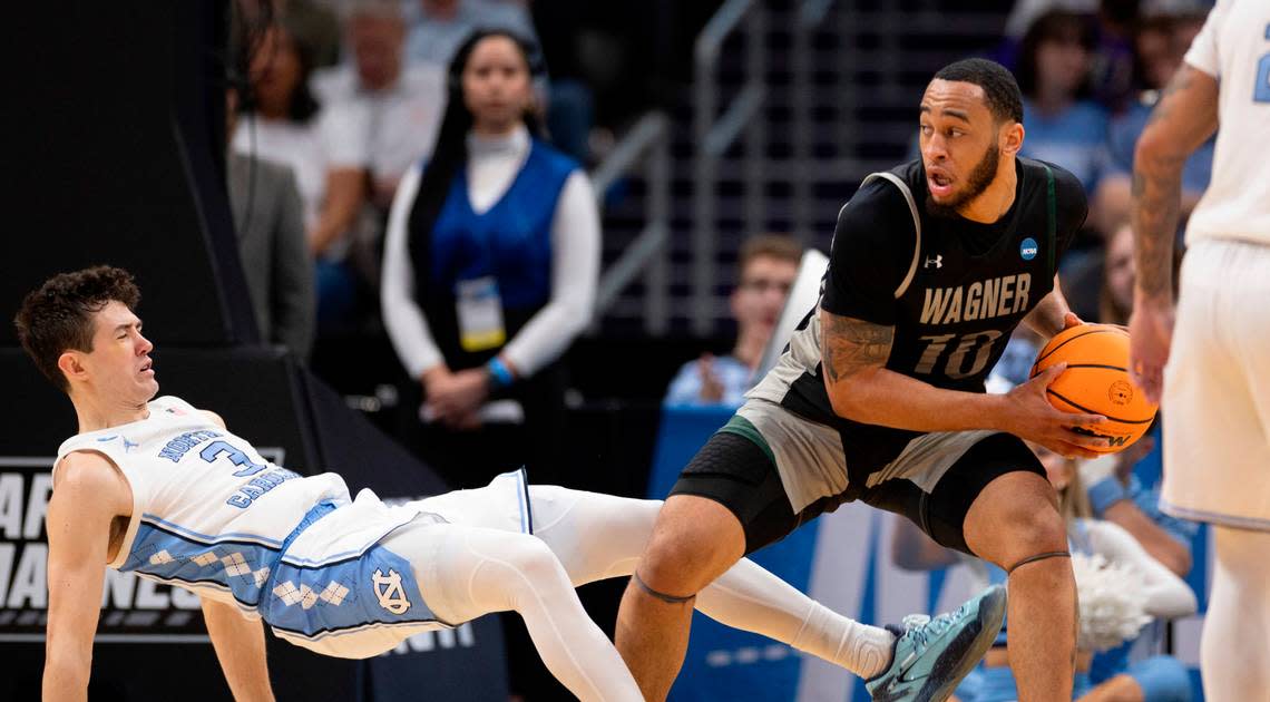 Wagner’s Tahron Allen (10) is called for charging after a collision with North Carolina’s Cormac Ryan (3) in the first half on Thursday, March 21, 2024 during the NCAA Tournament at Spectrum Center in Charlotte, N.C.