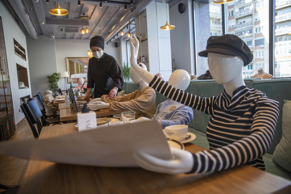 Mannequins are positioned at the tables of Bagolina eatery restaurant, as a protest against the latest government COVID-19 lockdown measures in Kosovo capital Pristina, Friday, April 9, 2021. Kosovar association of gastronomy have found an innovative way of protesting, sitting mannequins instead of customers in chairs of closed restaurants and cafeterias following the government's recent lockdown measures. (AP Photo/Visar Kryeziu)