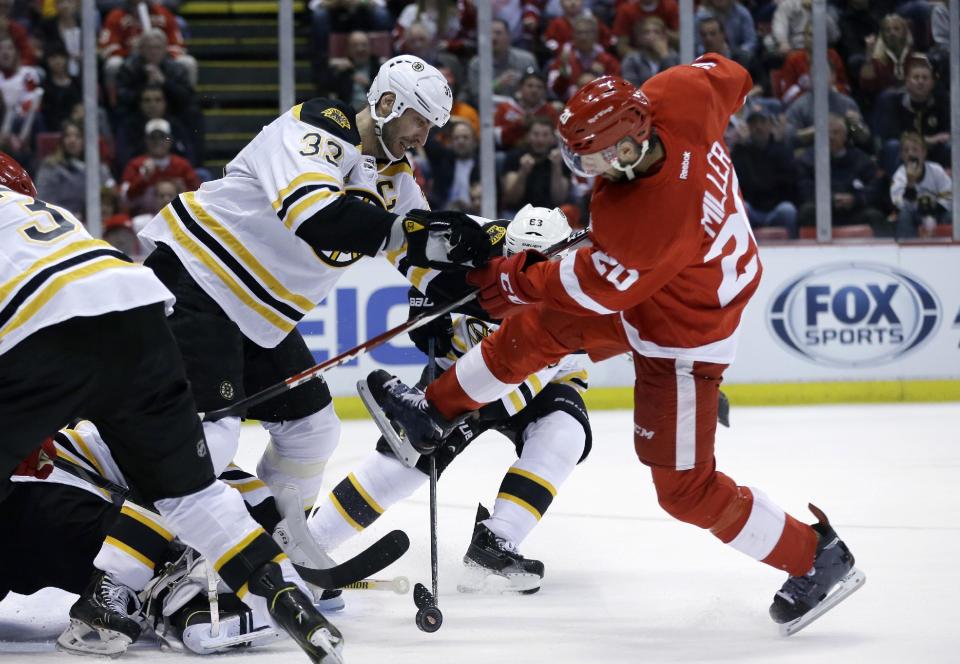 Boston Bruins defenseman Zdeno Chara (33) of the Czech Republic and Detroit Red Wings left wing Drew Miller (20) battle for the puck during the second period of Game 3 of a first-round NHL hockey playoff series in Detroit, Tuesday, April 22, 2014. (AP Photo/Carlos Osorio)