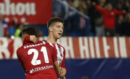 Atletico Madrid's Luciano Vietto (R) celebrates with team-mate Yannick Carrasco after scoring a goal during their Spanish first division derby soccer match against Real Madrid at the Vicente Calderon stadium in Madrid, Spain, October 4, 2015. REUTERS/Andrea Comas