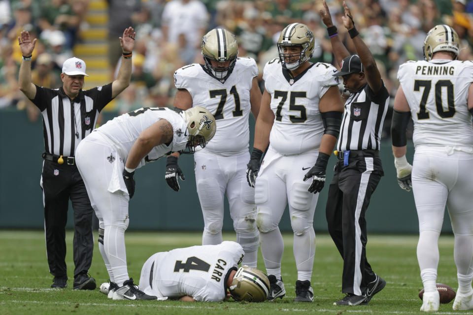 New Orleans Saints quarterback Derek Carr (4) lays on the turf after being hurt while being sacked during the second half of an NFL football game against the Green Bay Packers Sunday, Sept. 24, 2023, in Green Bay, Wis. (AP Photo/Matt Ludtke)