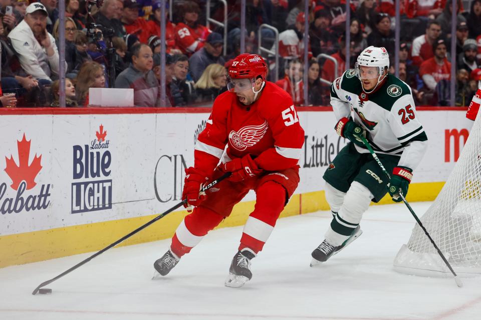 Detroit Red Wings left wing David Perron (57) skates with the puck chased by Minnesota Wild defenseman Jonas Brodin (25) in the second period at Little Caesars Arena in Detroit on Sunday, Nov. 26, 2023.