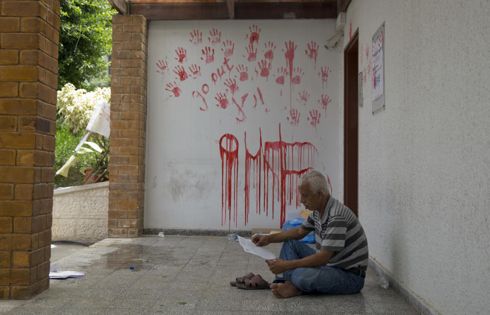 A Palestinian employee sits during a protest at the United Nations agency for Palestinian refugees (UNRWA) headquarters in Gaza City, Wednesday, July 25, 2018. UNWRA staff are protesting the agency's decision to fire dozens of Palestinian staff in Gaza in the Gaza Strip. (AP Photo/Khalil Hamra)