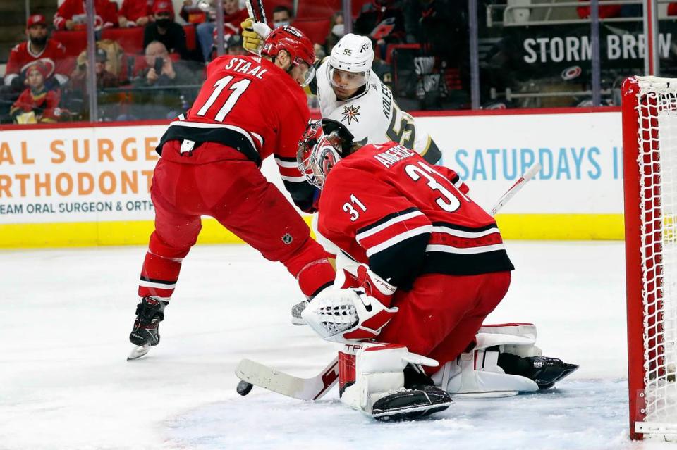 Vegas Golden Knights’ Keegan Kolesar (55) is tied up by Carolina Hurricanes’ Jordan Staal (11) as his shot is handled by goaltender Frederik Andersen (31) during the first period of an NHL hockey game in Raleigh, N.C., Tuesday, Jan. 25, 2022. (AP Photo/Karl B DeBlaker)