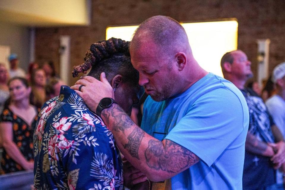 John Roddy, left, is embraced by Pastor Adam Brown while they pray. Roddy says his faith, as well as therapy, help him heal. Zachary Linhares/The Kansas City Star