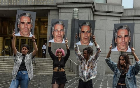 A protest group hold up signs of Jeffrey Epstein in front of the Federal courthouse - Credit: Stephanie Keith/Getty Images