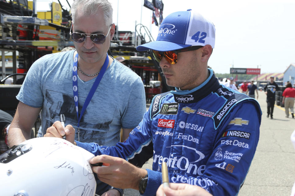 NASCAR driver Kyle Larson signs autographs after practice for the NASCAR Cup Series auto race in Brooklyn, Mich., Fruday, June 8, 2018. (AP Photo/Bob Brodbeck)