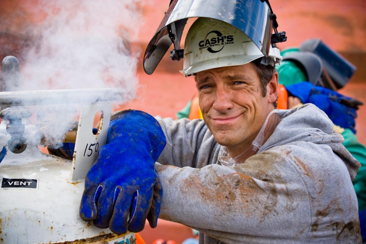 Portrait of host Mike Rowe next to venting gas on torch bottles. At Cash's Scrap Metal, St. Louis, Missouri in a scene from "Dirty Jobs"