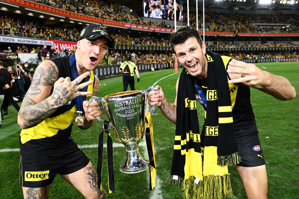 BRISBANE, AUSTRALIA - OCTOBER 24: Dustin Martin of the Tigers celebrates with the AFL Premiership Cup and captain Trent Cotchin of the Tigers after winning the 2020 AFL Grand Final match between the Richmond Tigers and the Geelong Cats at The Gabba on October 24, 2020 in Brisbane, Australia. (Photo by Quinn Rooney/Getty Images)