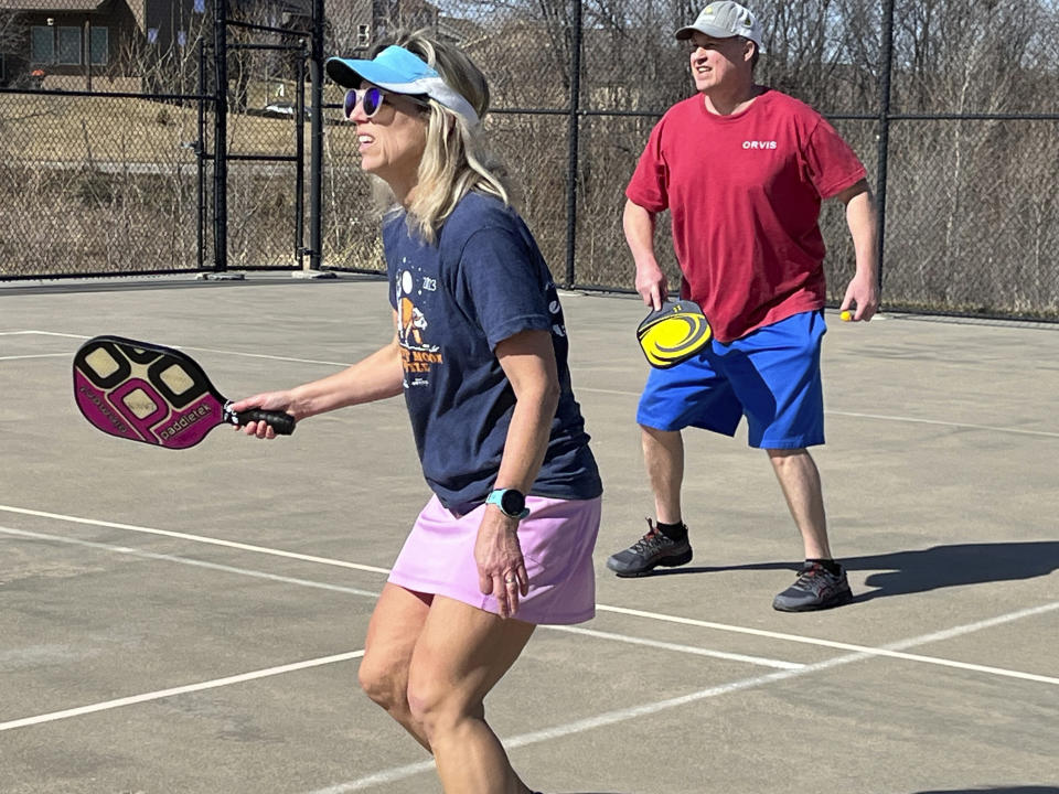 Stacy Lawson, left, and her husband, Hugh Lawson, play a game of pickleball on an outdoor court in Omaha, Neb., Sunday, Feb. 25, 2024. Temperatures usually hover around freezing this time of year. (AP Photo/Margery Beck)