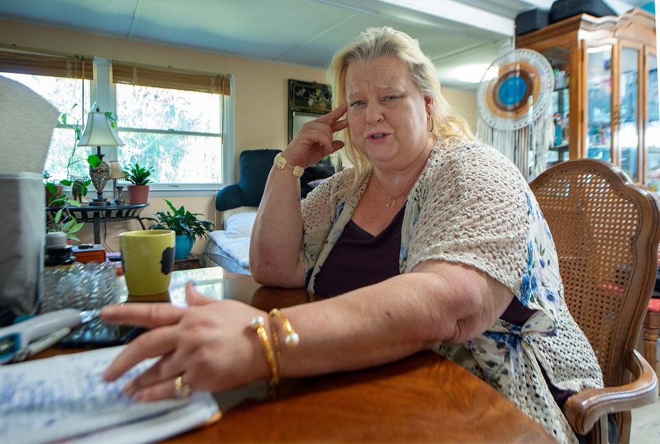 Karen McDonald recounts all the steps she had to take to be able get affordable housing, as she sits at her dining room table inside aher mobile home in Falls Township, on Monday, Nov. 8, 2021.