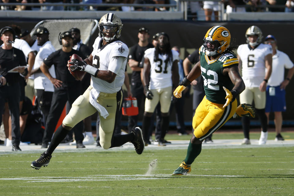 New Orleans Saints quarterback Jameis Winston, left, scrambles away from Green Bay Packers linebacker Rashan Gary (52) as he looks for a receiver during the first half of an NFL football game, Sunday, Sept. 12, 2021, in Jacksonville, Fla. (AP Photo/Stephen B. Morton)