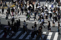 People wearing a protective face mask to help curb the spread of the coronavirus walk at Shibuya pedestrian crossing in Tokyo Thursday, July 2, 2020. Japan lifted a seven-week pandemic state emergency in late May, and social and business activity have since largely resumed. (AP Photo/Eugene Hoshiko)