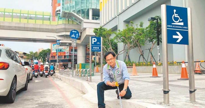 台中市議員張耀中12日到捷運南屯站五權西路實測路緣，高低竟達30公分，憂變身障朋友的「殺手坡」。（圖／盧金足攝）