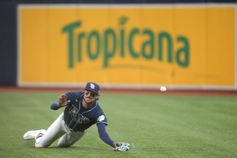 Tampa Bay Rays right fielder Josh Lowe dives but is unable to catch a ball in the fourth inning of Game 2 in an AL wild-card baseball playoff series against the Texas Rangers, Wednesday, Oct. 4, 2023, in St. Petersburg, Fla. (AP Photo/John Raoux)