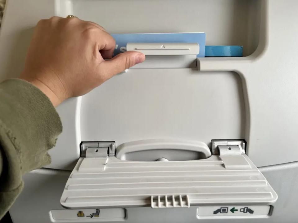 The author opening the phone stand on the seatback.