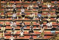 Sumo spectators wearing face mask practice social distance in their seats during the outbreak of the new coronavirus as they watch the first day of the sumo tournament in Tokyo, Sunday, July 19, 2020.(Kyodo News via AP)