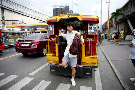 Oliver Emocling, 23, who works for a magazine, gets off a jeepney near his office in Makati City, Philippines, November 29, 2018. "When I get home, it's already 10 p.m.," said Emocling, who works at a magazine. "I could be using that time to sleep more, rest more. Instead, my time gets wasted". REUTERS/Eloisa Lopez