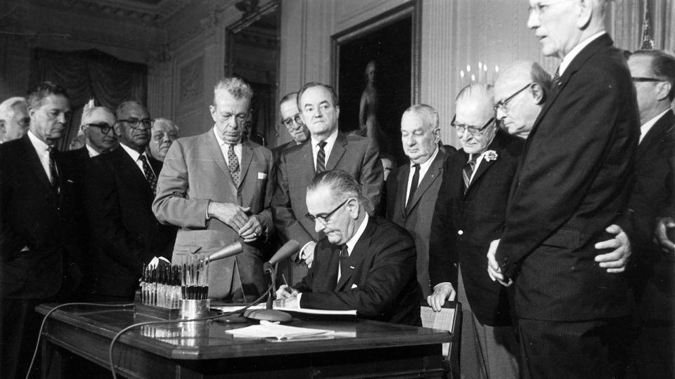 President Lyndon Baines Johnson signs the Civil Rights Act on July 2, 1964. The law made it illegal to discriminate on the basis of race, color, religion, sex, or national origin, and barred unequal application of voter registration requirements. - AP