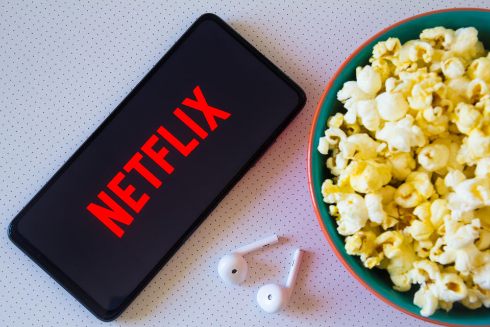 BRAZIL - 2022/04/19: In this photo illustration, the Netflix logo seen displayed on a smartphone along with a bowl of popcorn and headphones. (Photo Illustration by Rafael Henrique/SOPA Images/LightRocket via Getty Images)