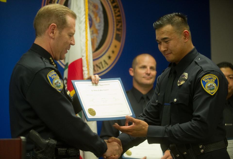 Jimmy Inn, right, is handed a certificate of appointment by Stockton Police Chief Eric Jones. Inn was one of 18 new police officers welcomed to the Stockton Police Department during a ceremony July 18, 2016, at the Stewart Eberhardt Building in downtown Stockton.