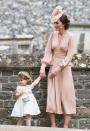 <p>Princess Charlotte played bridesmaid for Auntie Pippa’s May 2017 nuptials. The younger Middleton sister dressed her daughter in a traditional dress complete with a floral headband and basket of petals. (Photo: Getty Images) </p>