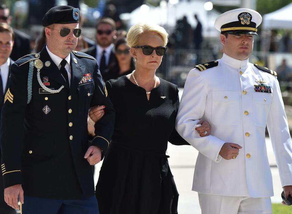 37) Jimmy McCain, son of John McCain, walks in the funeral processional with his mother and brother