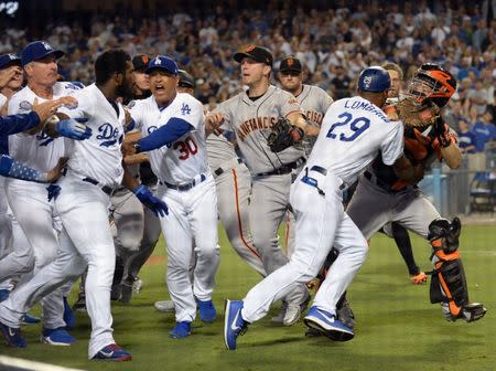 August 14, 2018; Los Angeles, CA, USA; Los Angeles Dodgers first base coach George Lombard (29) pushes away San Francisco Giants catcher Nick Hundley (5) as manager Dave Roberts (30) tries to hold back right fielder Yasiel Puig (66) in the seventh inning at Dodger Stadium. Gary A. Vasquez-USA TODAY Sports