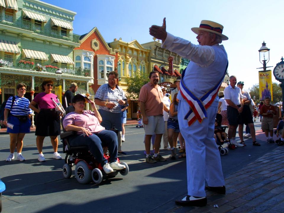 People gather to watch an actor on Main Street, USA in Disney world