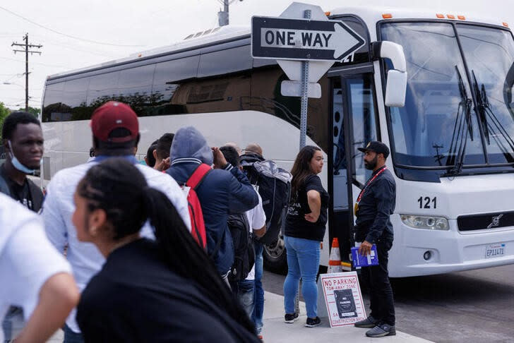 Migrantes esperan para abordar un bus al aeropuerto tras ser liberados luego de su procesamiento por agentes de inmigración en San Diego, Estados Unidos. Septiembre 21, 2023. . REUTERS/Mike Blake