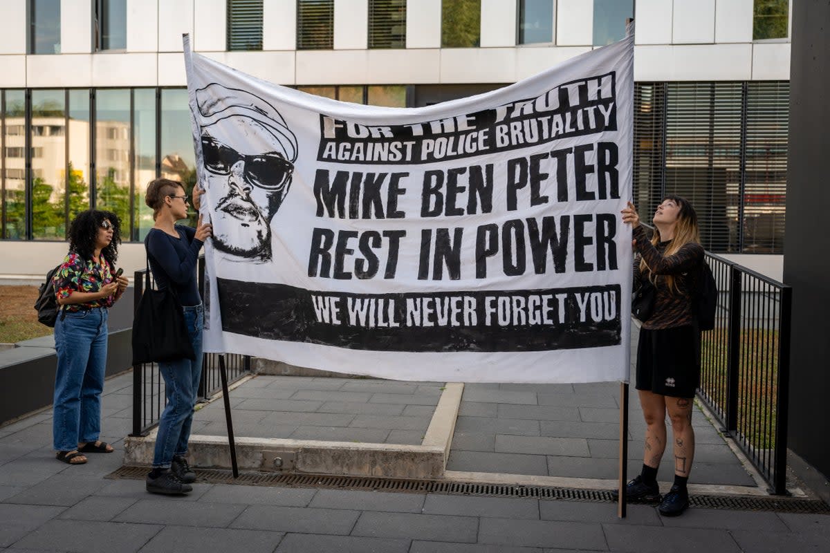 Activists hold a banner prior to opening of the trial of six policemen accused on homicide charges in relation to the death of 39-year-old Nigerian Mike Ben Peter, in Renens on 12 June 2023 (AFP via Getty Images)