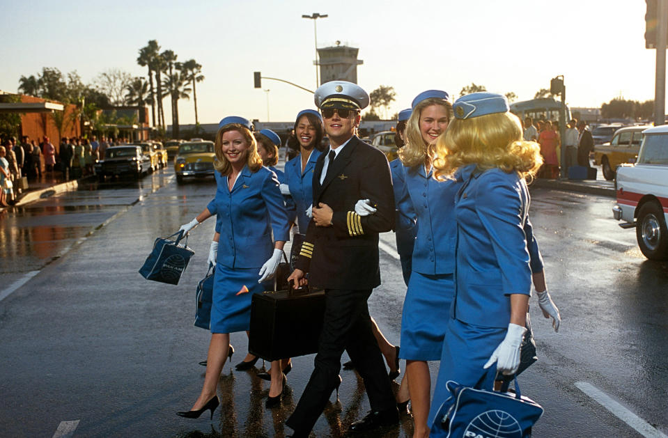 Leonardo DiCaprio walking with a group of flight attendants in "Catch Me if You Can"