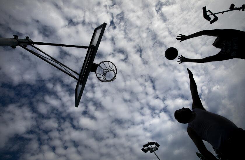 ENCINO, CA-SEPTEMBER 9, 2023: Antonio Macario,46, bottom, guards his son David, 16, while playing basketball at the Balboa Sports Center in Encino. They are from Los Angeles. (Mel Melcon / Los Angeles Times)