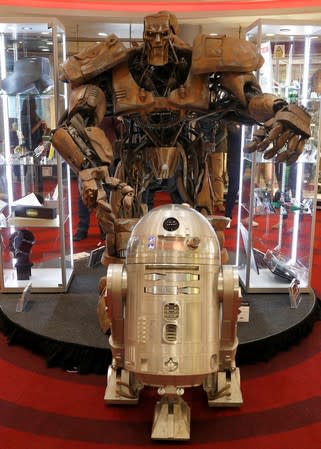 A R2-BHD droid which featured in "Star Wars: Rogue One: A Star Wars Story" stands in front of the ABC Warrior Robot from the film Judge Dredd, at a preview of a film and tv memorabilia sale in London