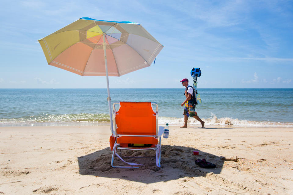 In this photo taken July 30, 2013, and made available by Visit Florida, Chris Officer carries a Google street view camera as he walks recording St. George Island beach in the Florida Panhandle. Visit Florida, the state's tourism agency, partnered with Google in the effort to map all 825 miles of Florida’s beaches. The Florida project is the first large-scale beach mapping project. (AP Photo/Visit Florida, Colin Hackley)