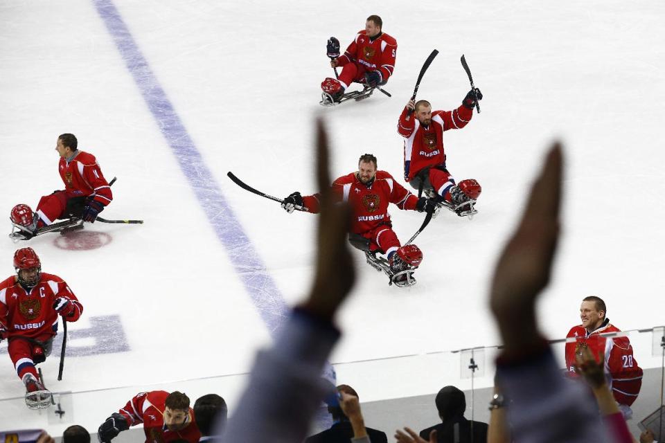 Russia players celebrate after winning the ice sledge hockey semifinal match against Norway during the 2014 Winter Paralympics in Sochi, Russia, Thursday March 13, 2014. Russia won 4-0. (AP Photo/Pavel Golovkin)