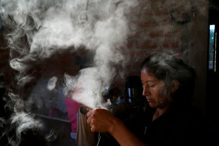 A member of FARC makes coffee in the morning in a camp near the transitional zone of Pueblo Nuevo, Colombia, February 5, 2017. REUTERS/Federico Rios